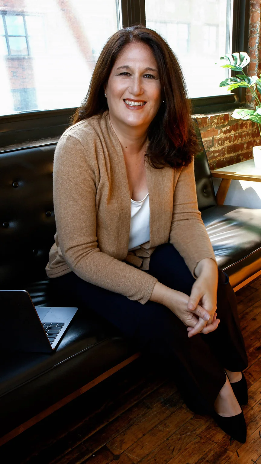 Amy Miller smiling at camera beige sweater